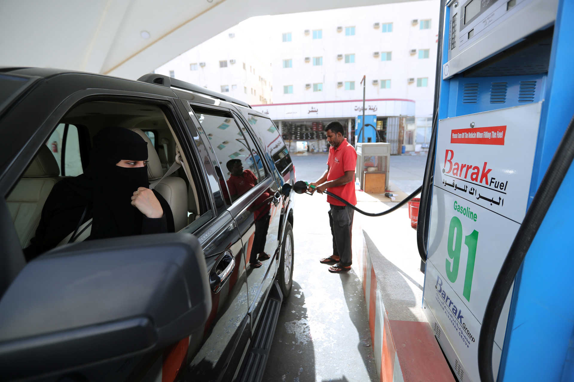 A Saudi woman, Amira, who works in Aramco, refuels her car as she makes her way to her office in Dammam