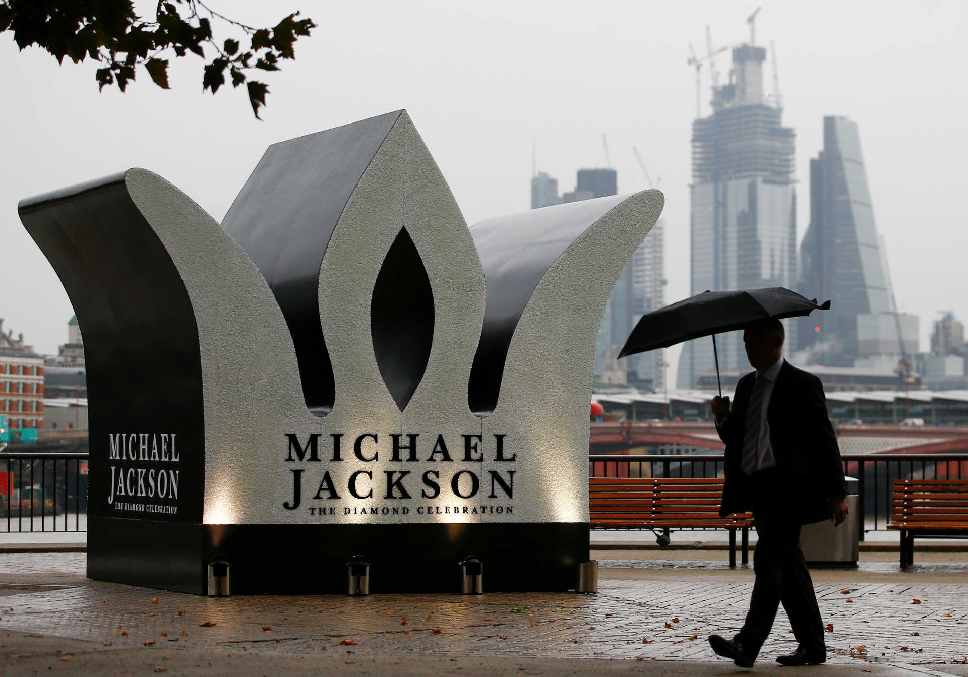 A man walks past a Giant Crown installed to celebrate the 60th birthday of Michael Jackson, on the South Bank in London
